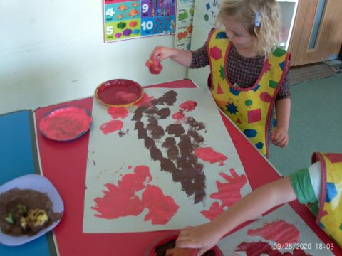 a child using a sponge to paint a picture of a leaf